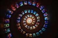 Captivating spiral stained glass art with vibrant colors forming a dramatic eye-catching pattern.