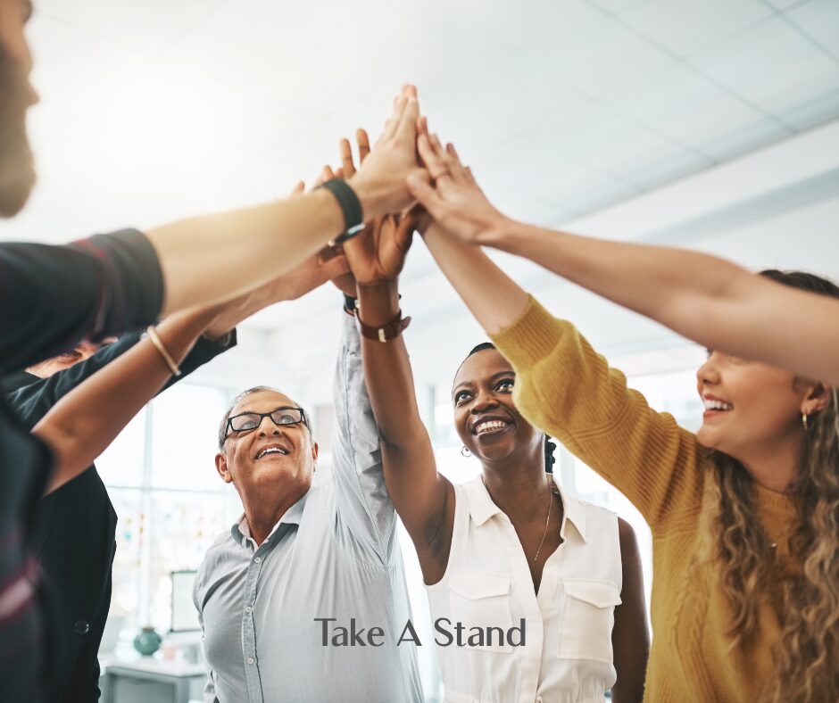 Group of people high fiving together, symbolizing unity and collective action.