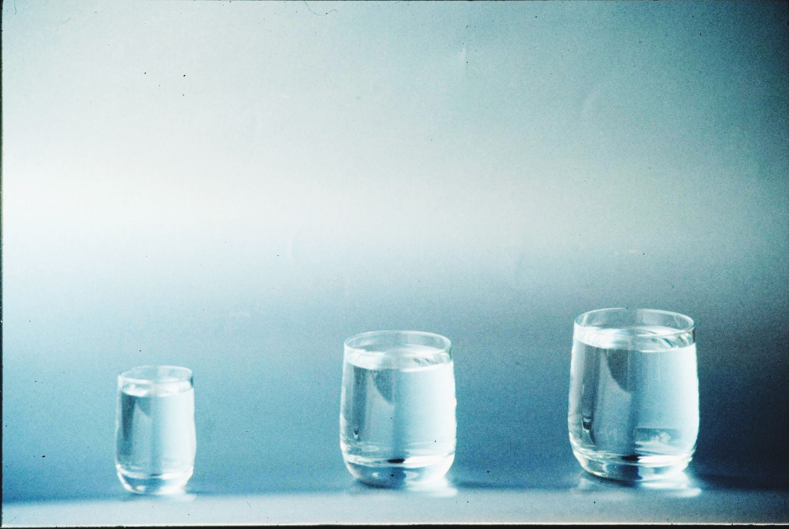 Water: Beyond 8 Glasses — The Mineral Chemistry Your Body Actually Needs 8 A minimalist image showcasing three different-sized glasses filled with water.