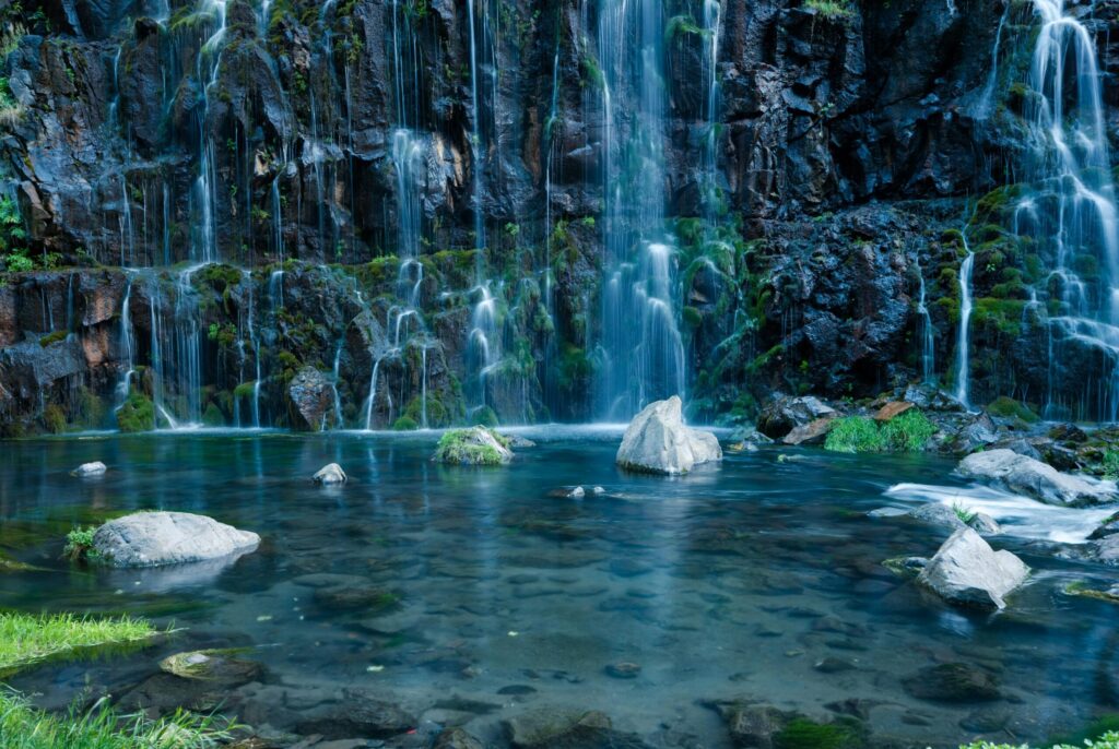 Clear mineral spring water emerging from natural rock, representing the ionic mineral content of natural water beyond simple H₂O — Busting Nutrition Myths Article VII by Bomi Joseph MD PhD