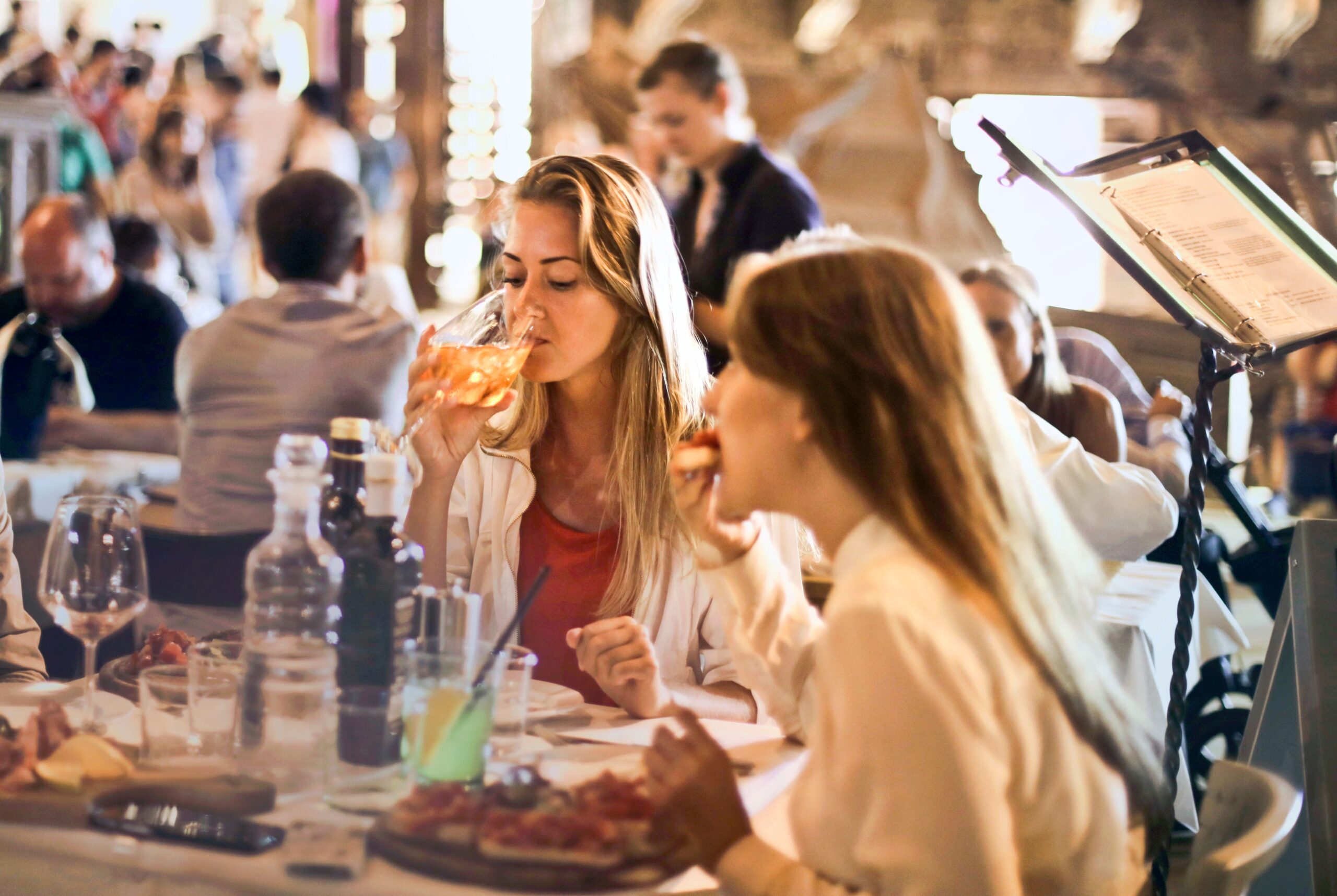 Water: Beyond 8 Glasses — The Mineral Chemistry Your Body Actually Needs 10 Friends dining in a cozy Italian restaurant, enjoying drinks and food in a lively atmosphere.