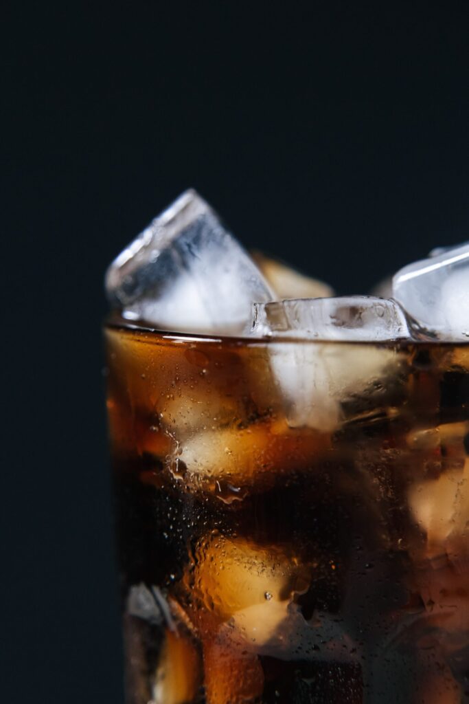 Extreme close-up of a cold drink with ice cubes in a glass, refreshing and inviting.