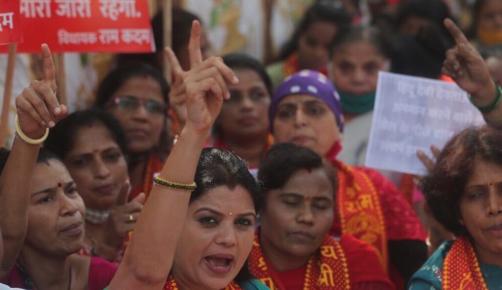 India after sixty years - women at a BJP political rally in India holding signs and shouting slogans.