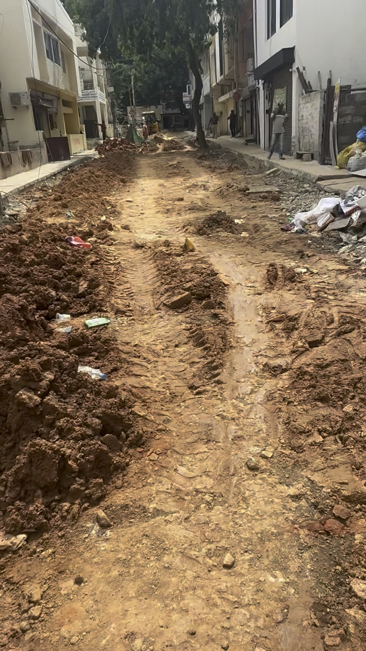Dug-up muddy road with deep ruts in Domlur, a central area of Bangalore.