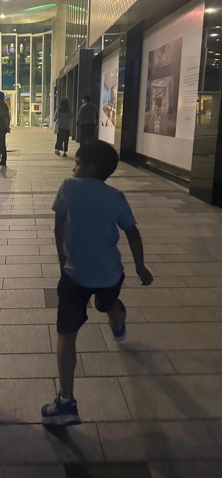 Young boy cheerfully skipping on a clean city street in Seoul.