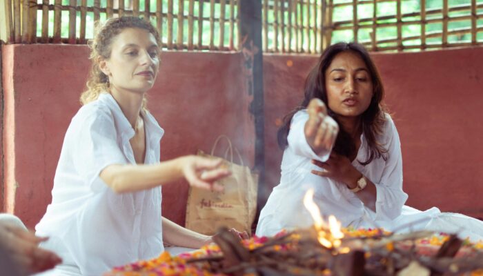 Spiritual India 1975 Agni Prayer American woman and Indian woman in a simple hut in India in 1975 offering incense into an Agni flame during prayer.